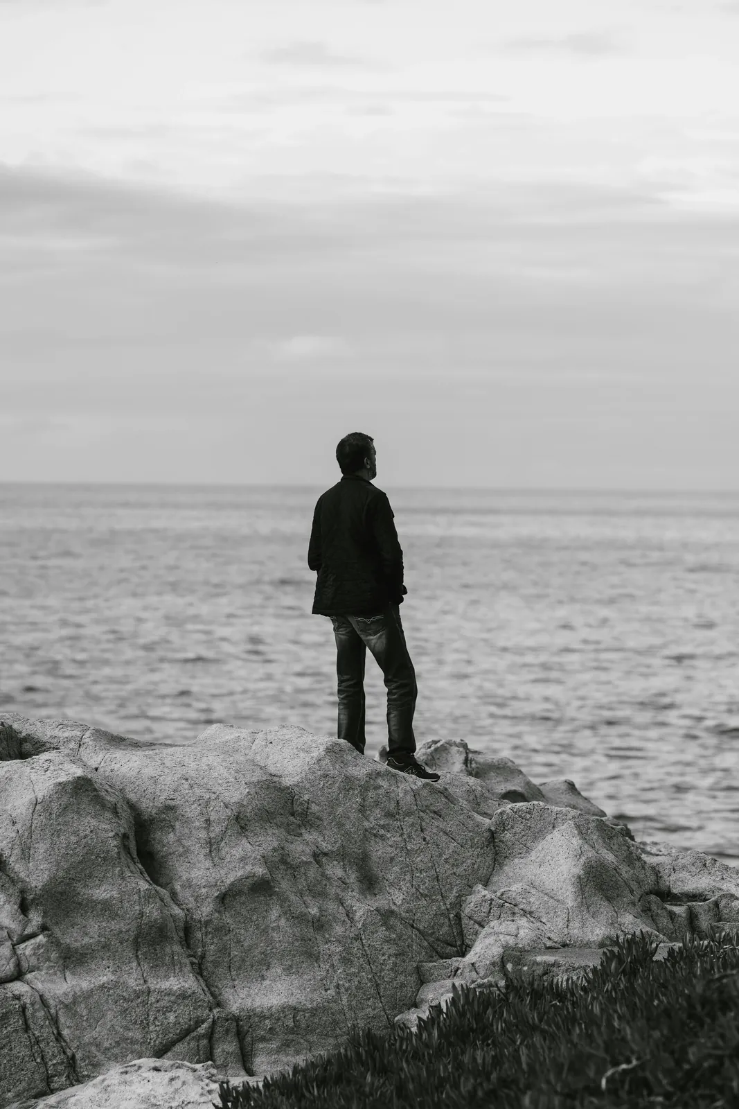 Hombre observando el mar en soledad, fotografía en blanco y negro